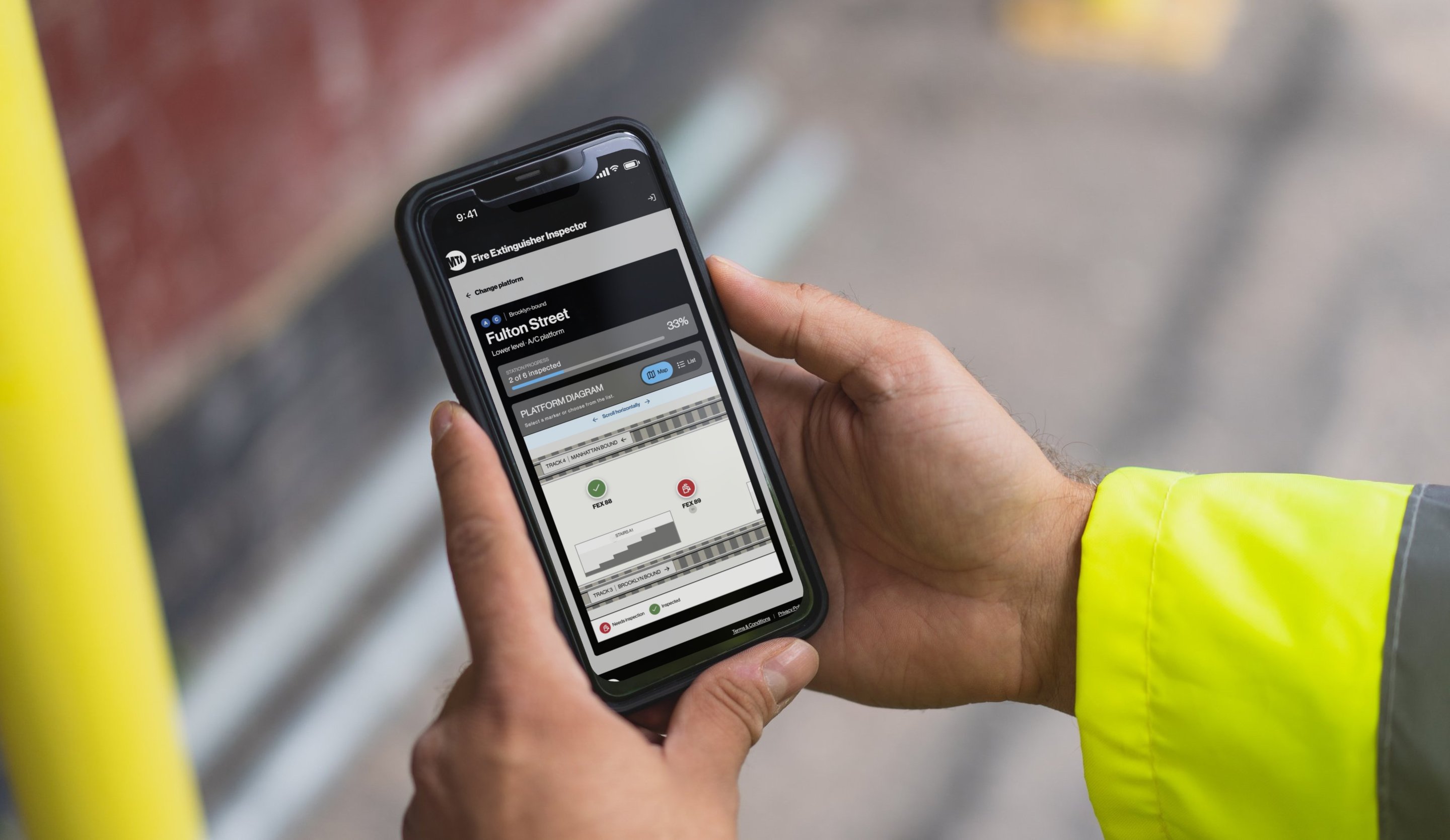 An inspector holding an iPhone running the Fire Extinguisher Inspector app